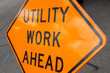 Tilted orange utility work ahead sign