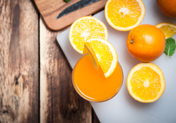 Wall Mural - fresh fruits orange juice in glass on wood