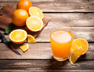 Wall Mural - fresh fruits orange juice in glass on wood,selective focus on gl