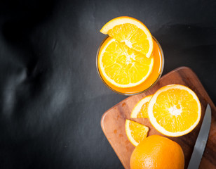 Wall Mural - fresh fruits orange juice in glass on on a black slate
