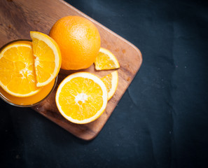 Wall Mural - fresh fruits orange juice in glass on on a black slate