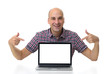 © spaxiax - man sitting at desk and pointing on laptop with blank screen