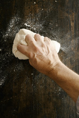 Wall Mural - Chef preparing dough kneading it with his hand