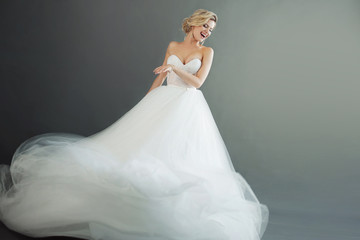 charming young bride in luxurious wedding dress. pretty girl in white. emotions of happiness, laught
