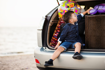 Wall Mural - Beautiful woman with a child of four years in the car are going to have a trip