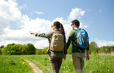 happy couple with backpacks hiking outdoors