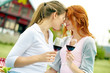 © pressmaster - Portrait of two affectionate women with wine glasses outdoors
