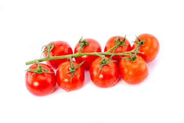 Canvas Print - Branch of red cherry tomatoes sprinkled with water and isolated on a white background.