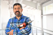 © R. Gino Santa Maria - Hispanic Man Holding Drill