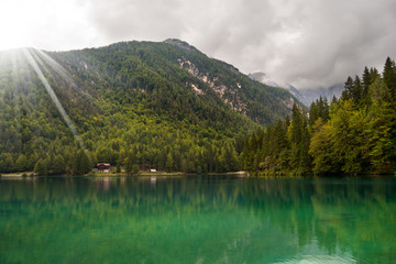 Lago di Fusine (Fusine Lake) in mountain with forest and green water. Julian Alps, Friuli, Italy