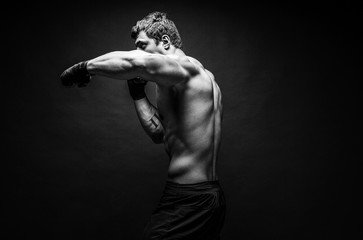 Wall Mural - Studio portrait of fighting muscular man in smoke.