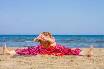 Wall Mural - Young woman practicing morning meditation at the beach