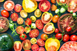 A lot of fresh and ripe tomatoes of different sizes and colours – top view