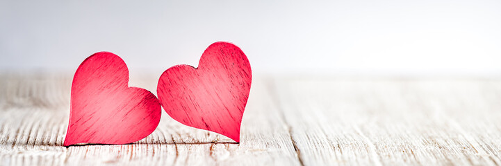 Wall Mural - two red hearts on wooden background