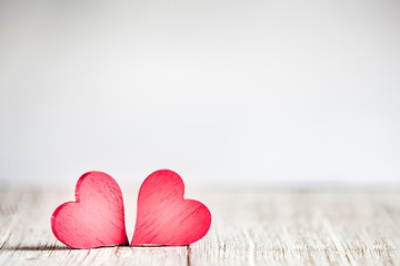 Wall Mural - two red hearts on wooden background