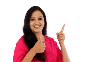 Wall Mural - Happy young woman making thumbs up gesture against white backgro