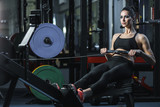 Concept: power, strength, healthy lifestyle, sport. Powerful attractive muscular woman CrossFit trainer do workout on indoor rower at the gym