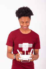 African American young man holding a drone remote control over w