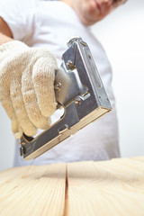 Wall Mural - Male installer using stapler for wooden plank