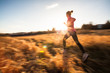 © lightpoet - Young woman running outdoors on a lovely sunny winter/fall day