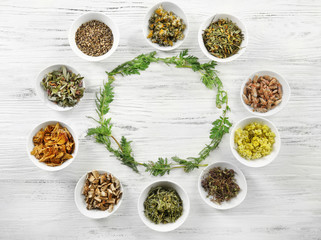 Natural flower and herb selection in  bowls on wooden background