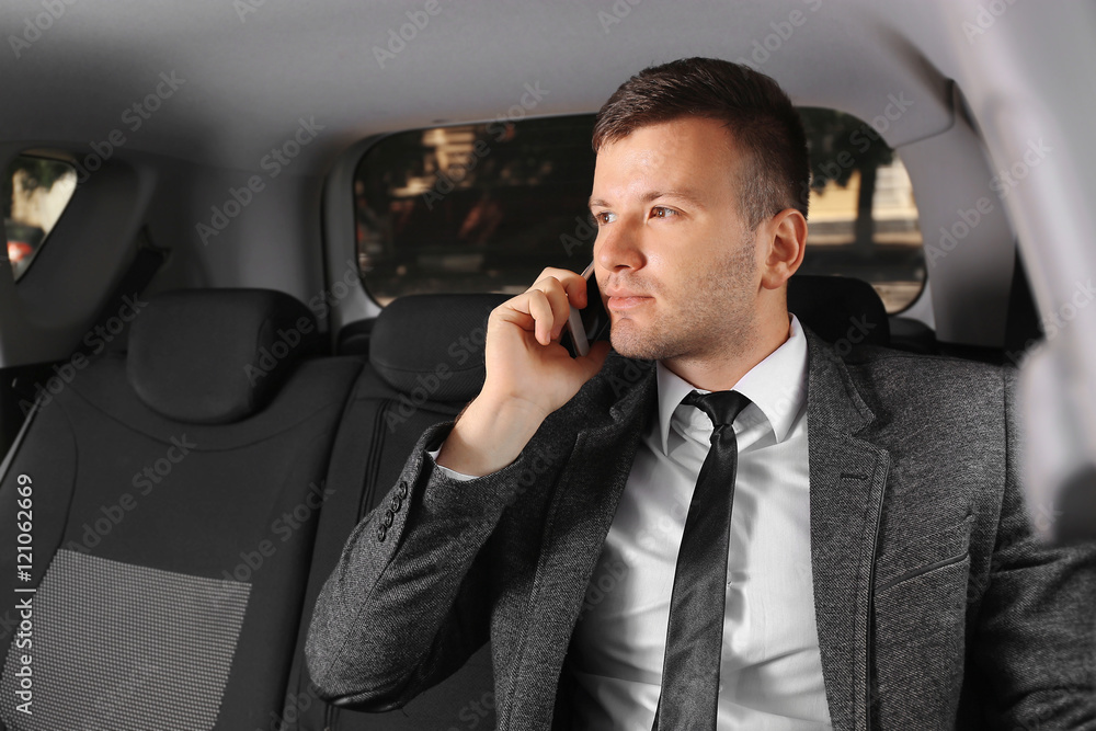 Businessman speaking by cellphone in  a car