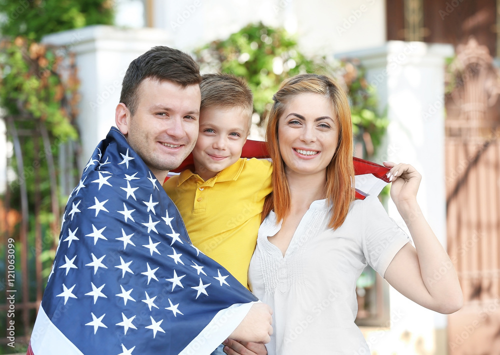 Happy family with American flag in the yard
