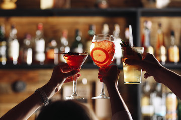 Friends toasting with cocktails in bar