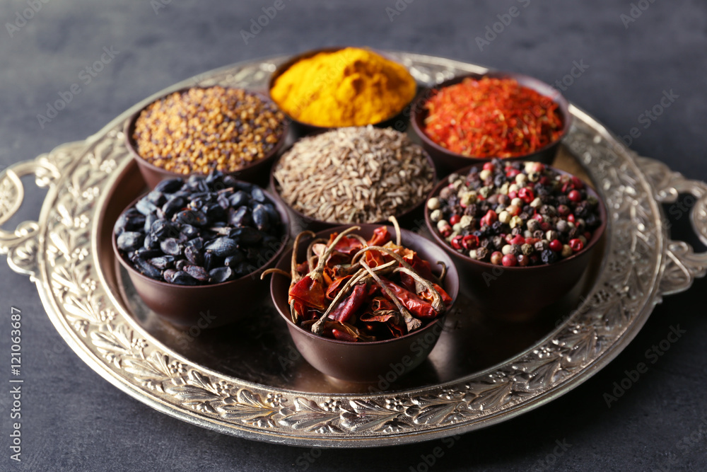 Different spices in bowls on tray