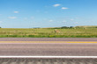 Hay bales and fields next to a road in northern Nebraska on a summer day. 