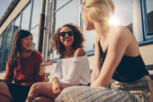 Three Young Women Meeting At Outdoor Cafe
