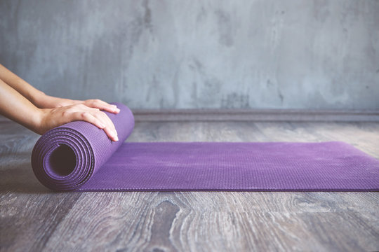 woman rolling her mat after a yoga class