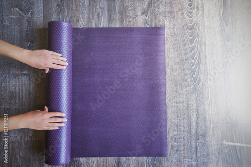 Fotografie, Obraz Woman rolling her mat after a yoga class