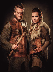 Wall Mural - Vikings couple posing in studio on dark background.