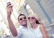 © Syda Productions - smiling couple with smartphone in the city