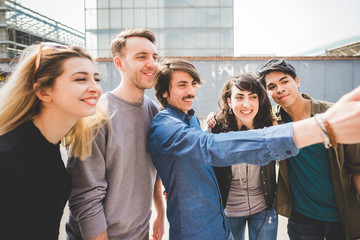 Wall Mural - Group of young multiethnic friends taking a selfie with smart phone handhold , having fun - friendship, relaxing concept