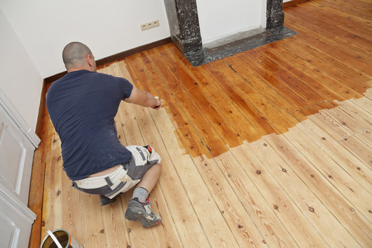 Fototapete -  - homme mettant huile de protection sur plancher au rouleau