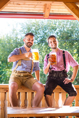 Wall Mural - Men in traditional bavarian clothes holding mugs of beer