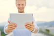 © Loginova - Working on tablet computer. Handsome young man using digital tablet outdoor.