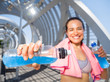 Happy female runner with energetic drinks for hydration