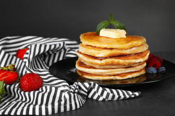 Wall Mural - Tasty pancakes with fresh berries, butter and sweet honey on plate on grey background