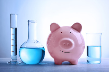 pig money box and water in tubes on table. saving water concept
