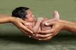 © jbrown - African American Parent Hands Holding Their Newborn