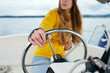 Woman's hand on the steering wheel of the boat