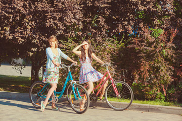 Wall Mural - The two young girls with bicycles in park