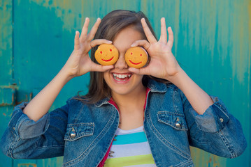 Cookies in the form of smiley. Teen girl eating cookies, snack for schoolchildren. Cheerful teen girl with cookies. people, happy childhood, food, sweets and bakery concept