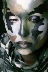 Wall Mural - Beautiful young fashion woman with military style clothing and face paint make-up, khaki colors, halloween celebration close up, green pattern