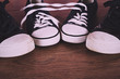 © Christopher Hall - Old canvas shoes on a wooden floor Vintage Retro Filter.