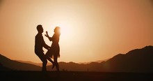 Romantic Young Couple Silhouette. Woman Running To Her Man And They Hug And Spin At Sunset Golden Hour, Slow Motion