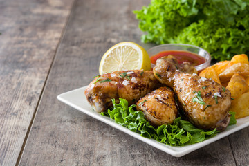 Poster - Roast chicken drumsticks and chips on wooden table

